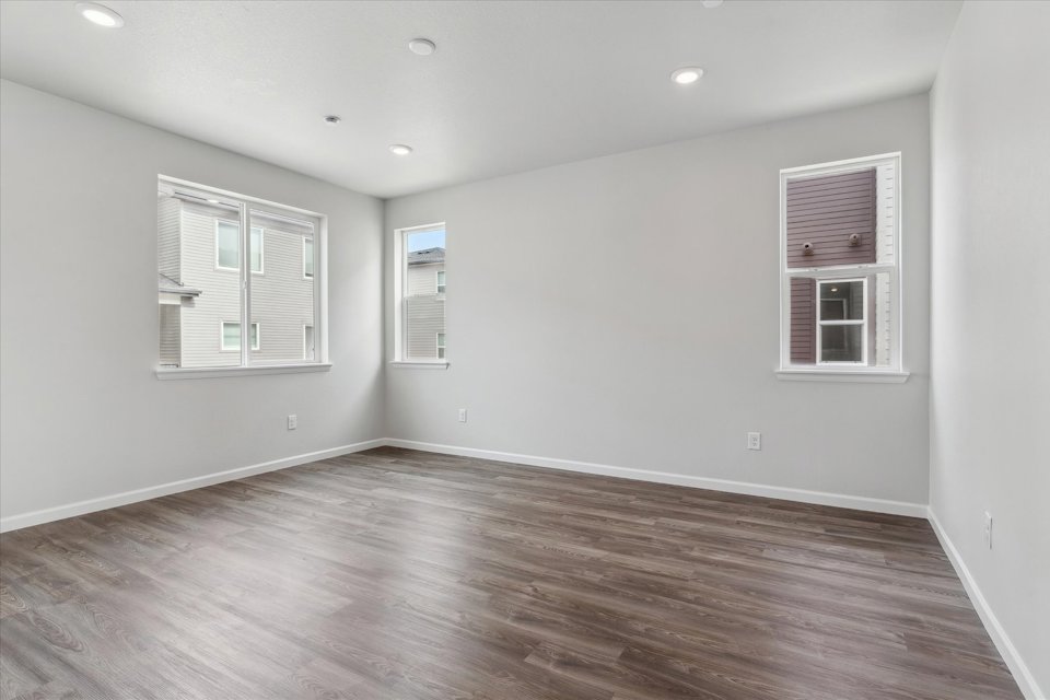 A room with a wood floor and windows.