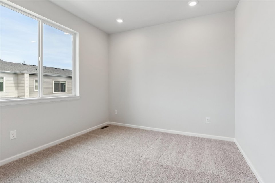 A room with a window and a carpet.