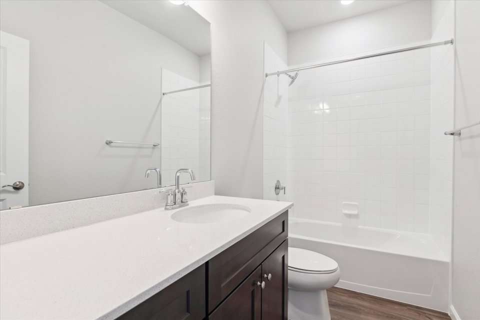 A bathroom with a tub sink and toilet.