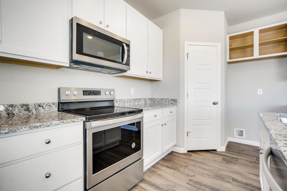 A kitchen with white cabinets.