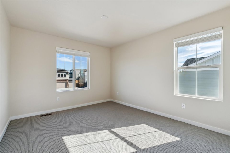 A room with windows and a rug.
