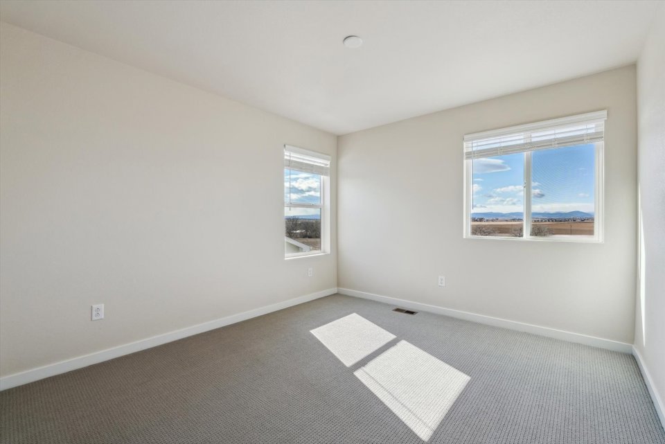 A room with a window and a rug.