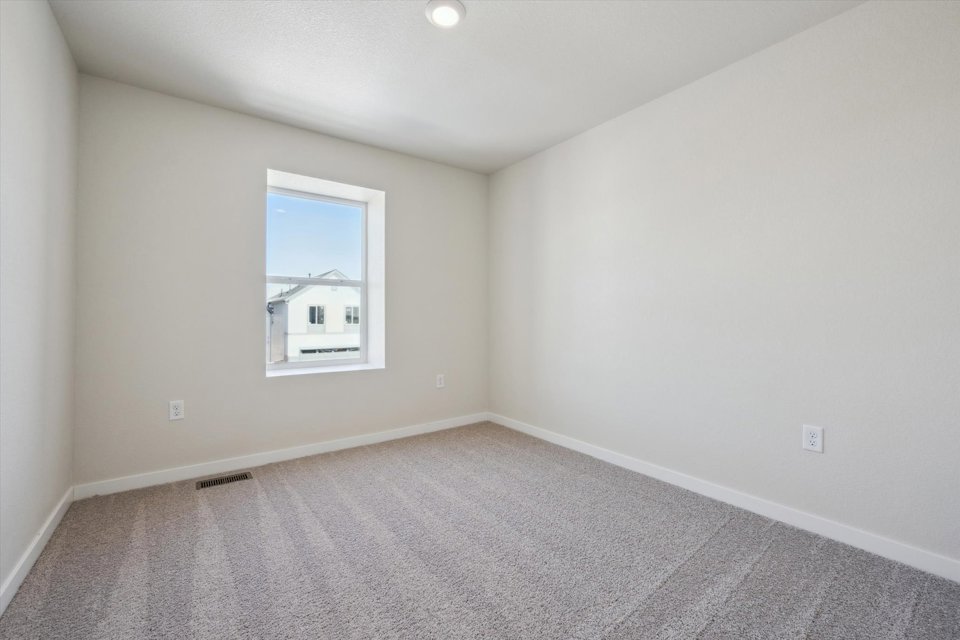 A room with a window and a carpet.