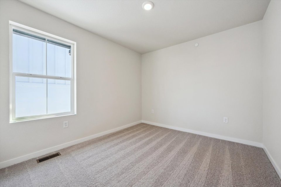 A room with a window and a carpet.