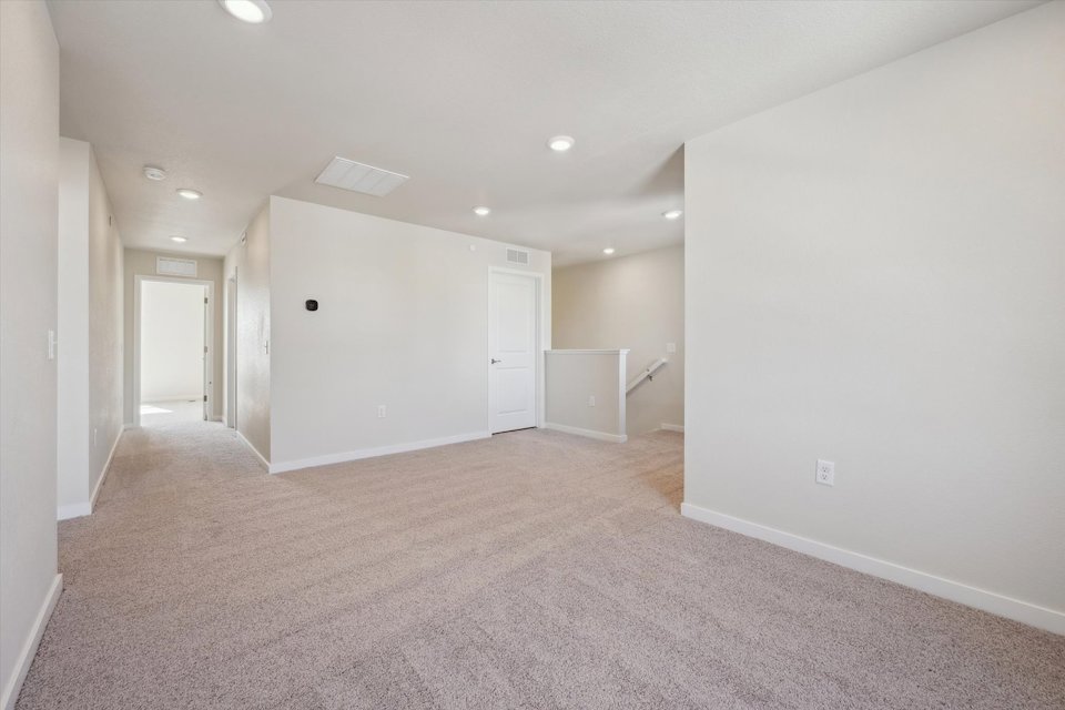A long hallway with white doors.