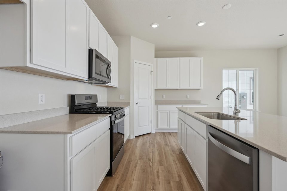 A kitchen with white cabinets.