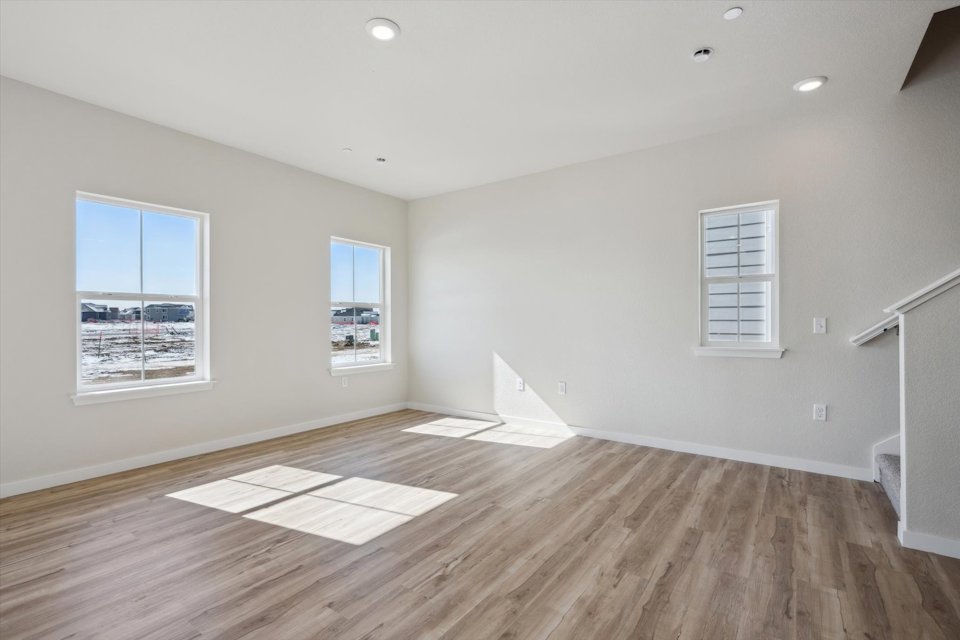 A room with a wood floor and a rug and a window.
