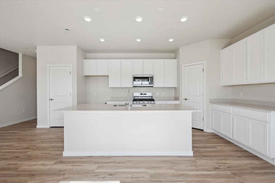 A kitchen with white cabinets.
