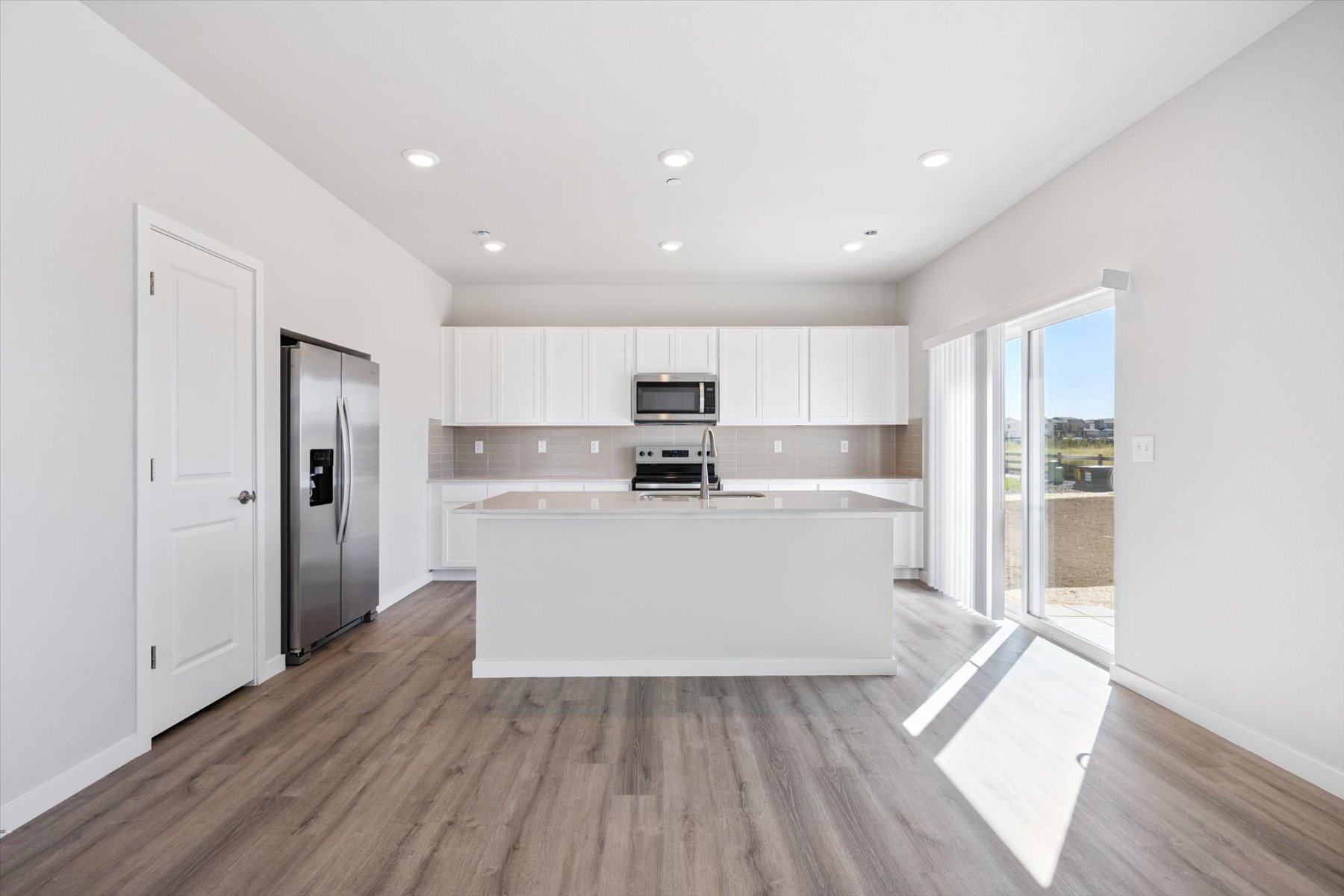A kitchen with white cabinets.
