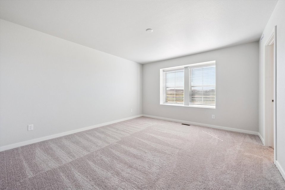 A room with a carpet and a window.