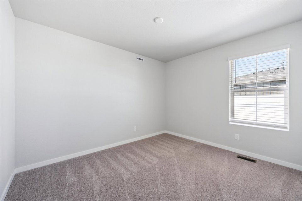 A room with a carpet and a window.