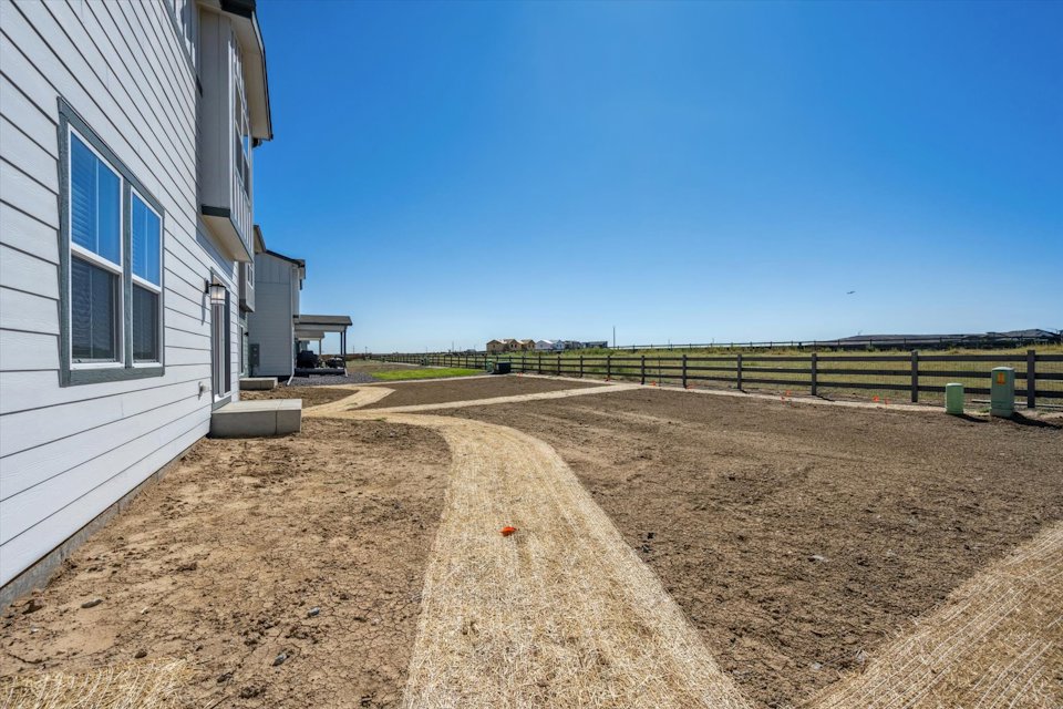 A dirt road between buildings.