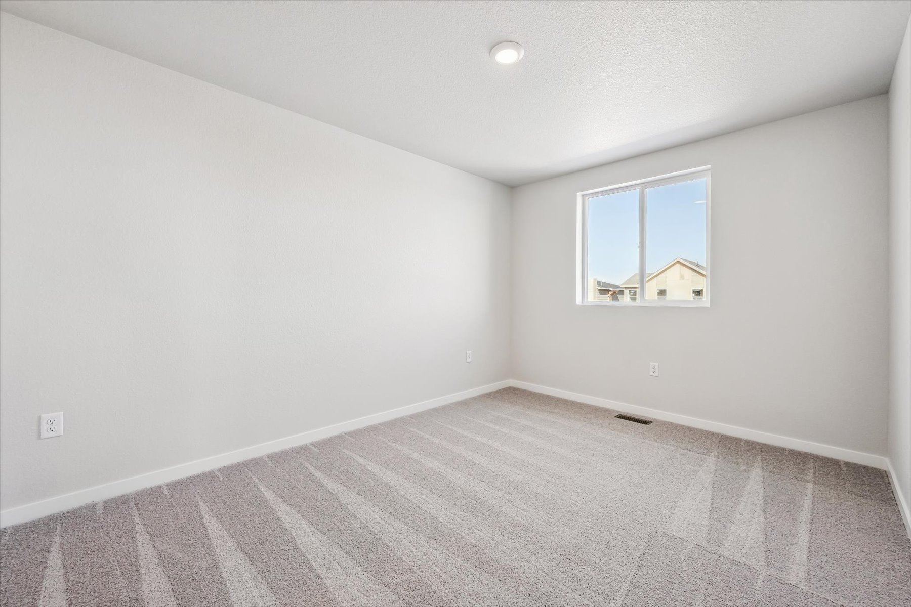 A room with a window and a rug.