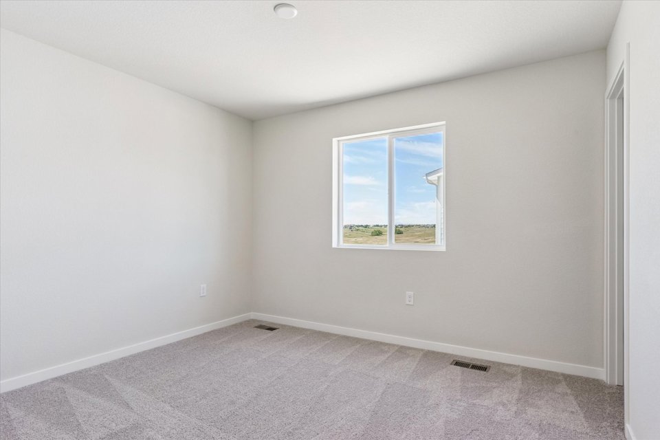 A room with a window and carpet.