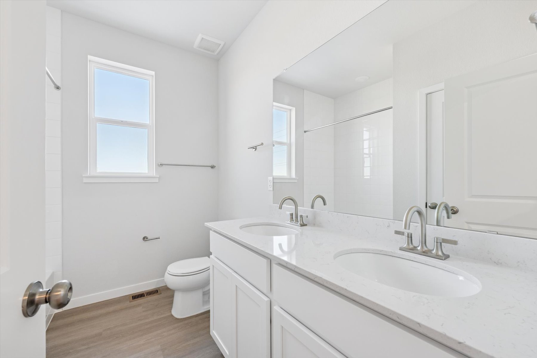 A bathroom with white cabinets.