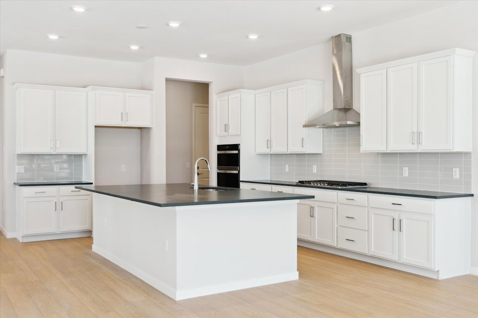 A kitchen with white cabinets.
