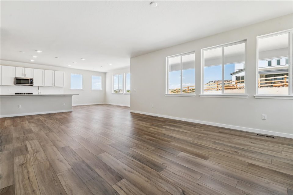 A large empty room with white cabinets.