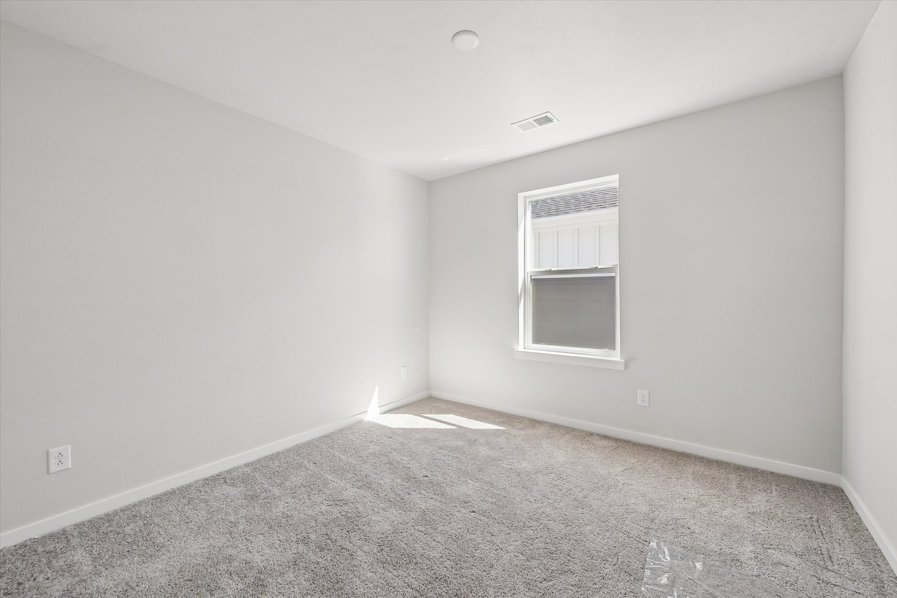 A room with a window and carpet.