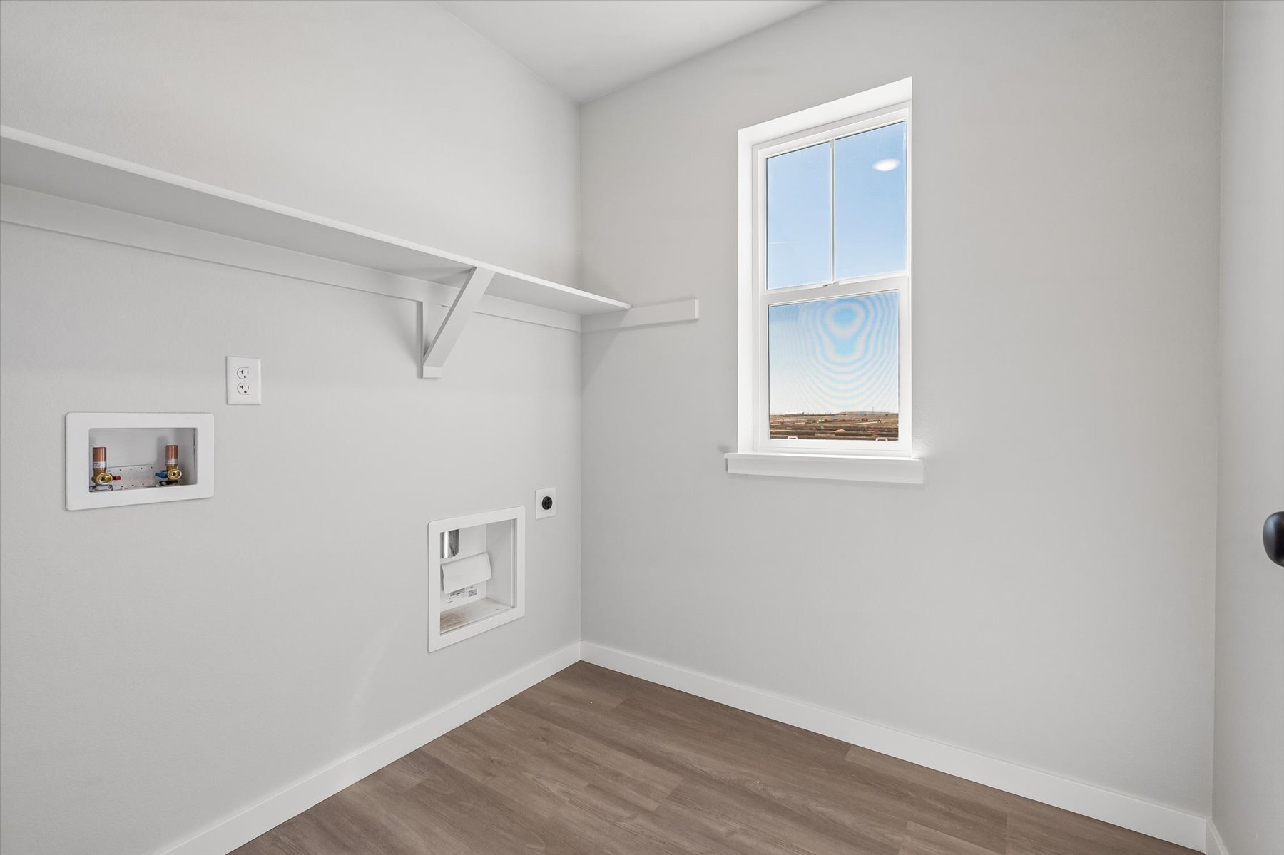 A room with white walls and a wood floor with a wood floor.