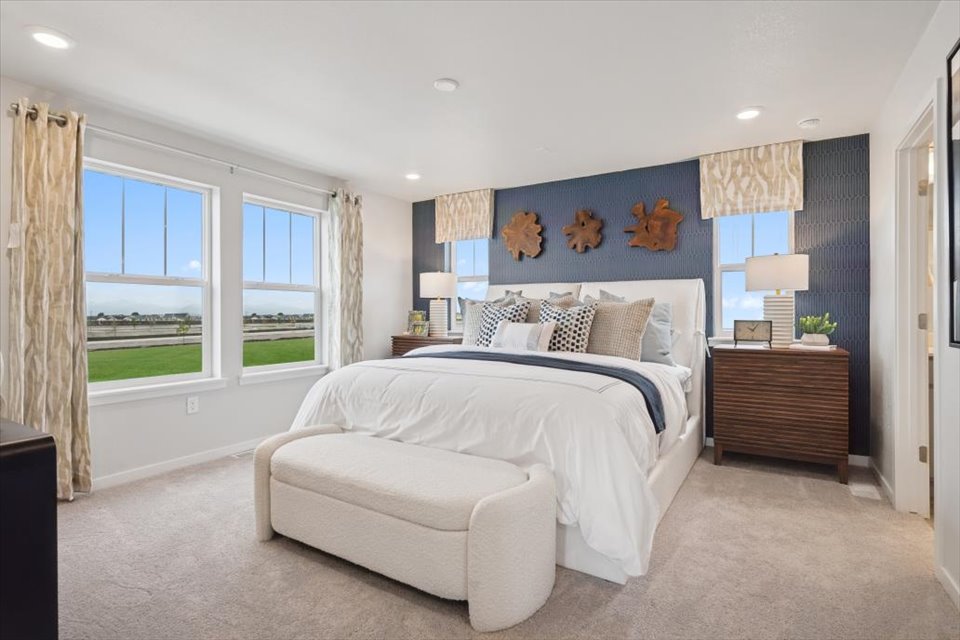 A bedroom with a large bed and a large window.