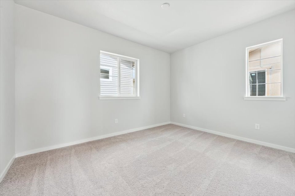 A room with a window and a white wall.