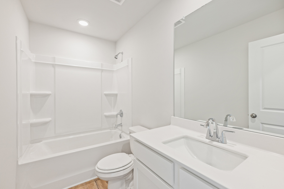 A bathroom with a tub sink and toilet.