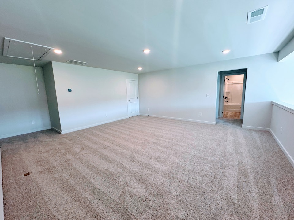 A room with a carpet and a door.