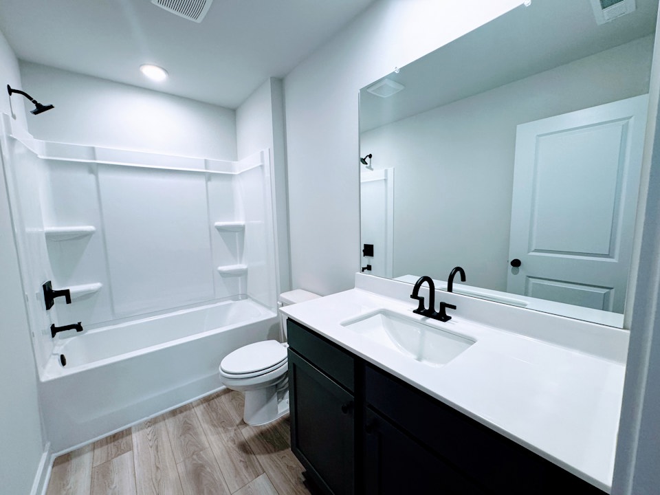 A bathroom with a tub sink and toilet.