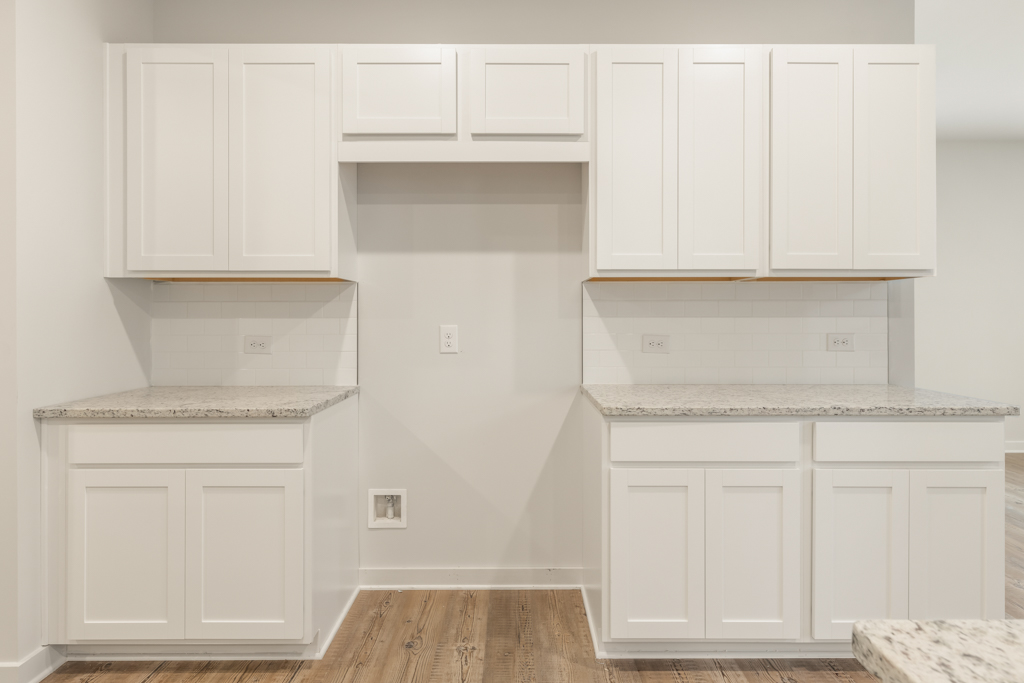A kitchen with white cabinets.