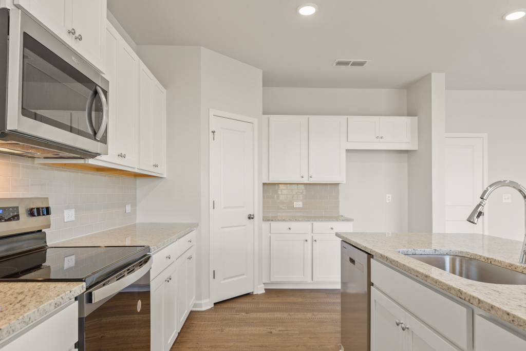 A kitchen with white cabinets.