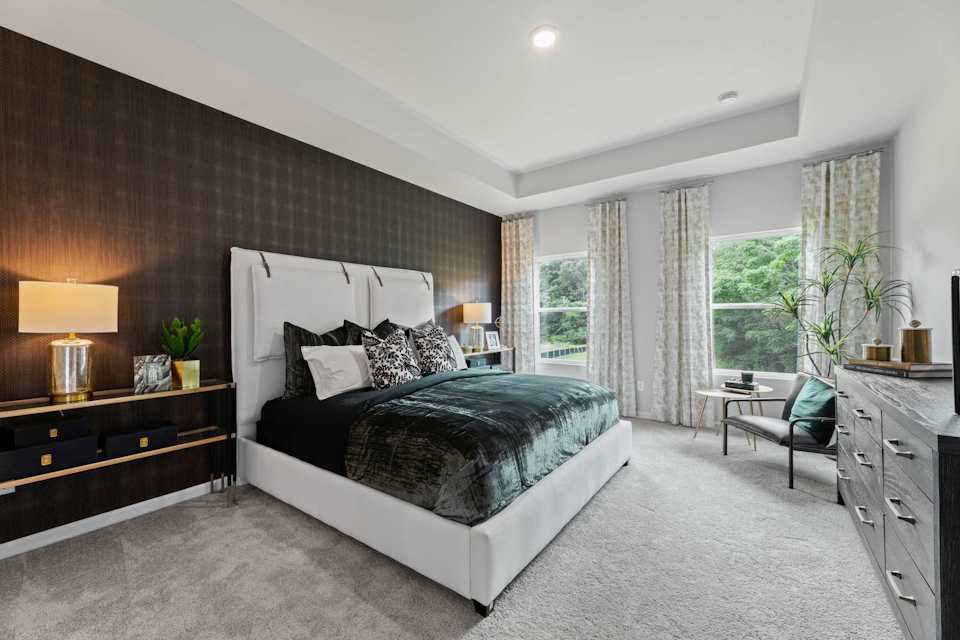 A bedroom with a bed and a chair.