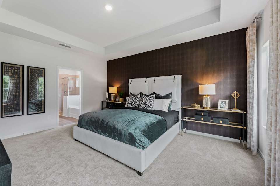 A bedroom with a bed and lamps.