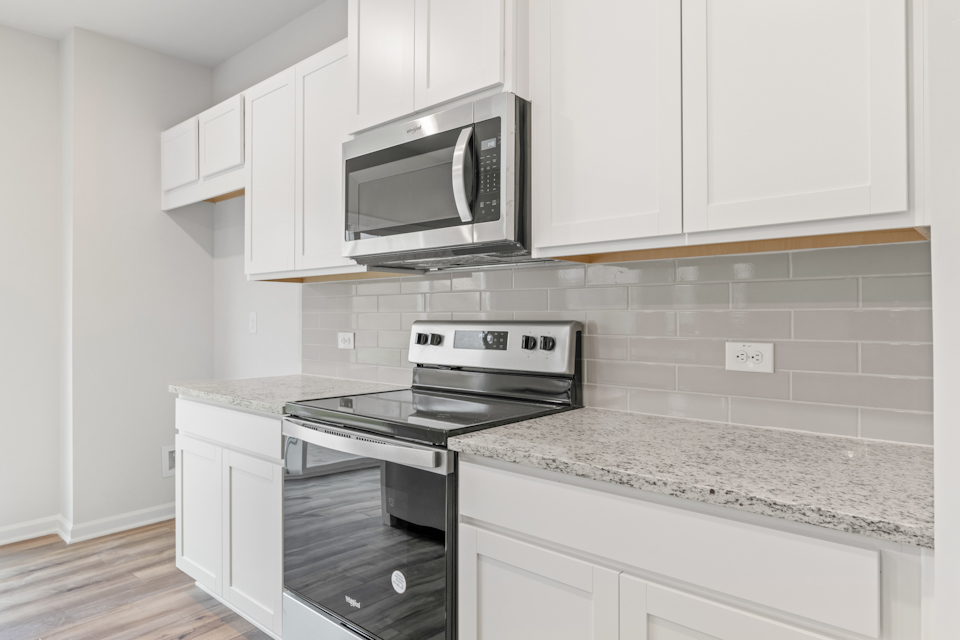 A kitchen with white cabinets.