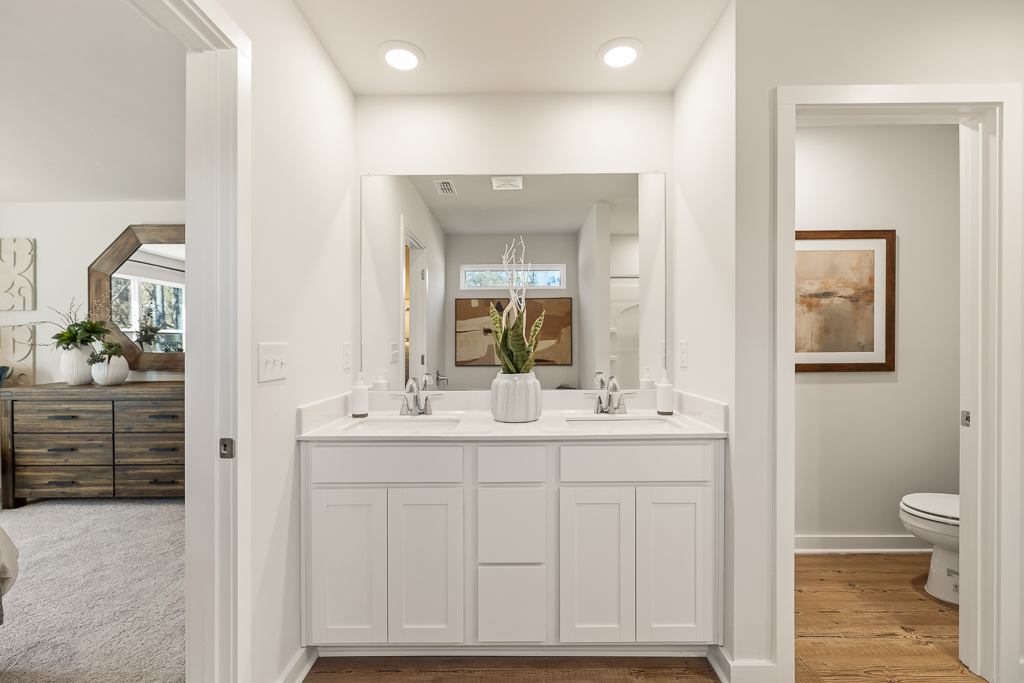 A bathroom with white cabinets.