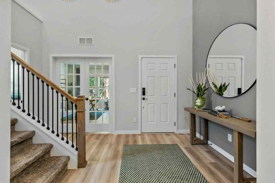 A room with a staircase and a mirror.