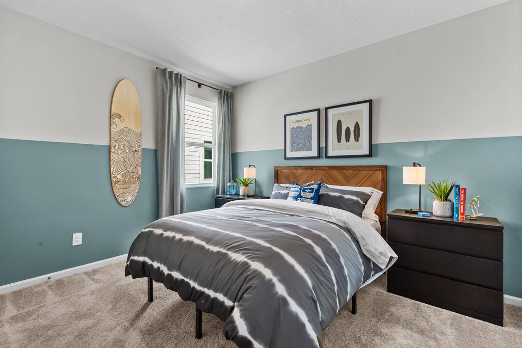 A bedroom with a bed and a dresser.