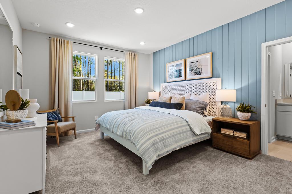 A bedroom with a bed and a chair.