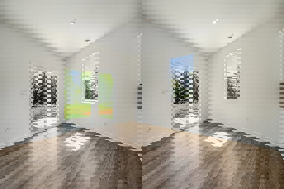 A room with a wood floor and windows.