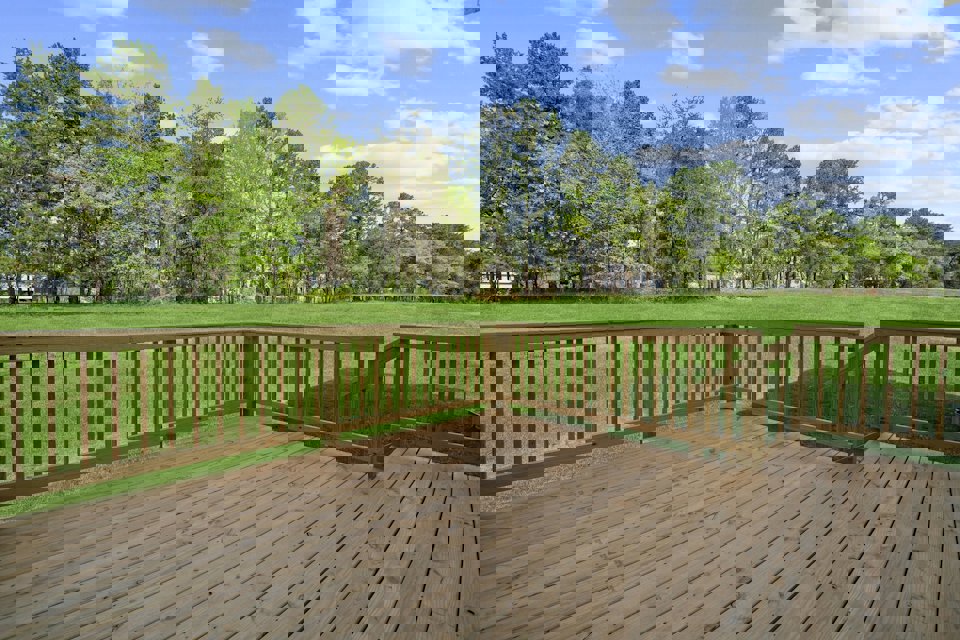 A wooden deck with trees in the background.