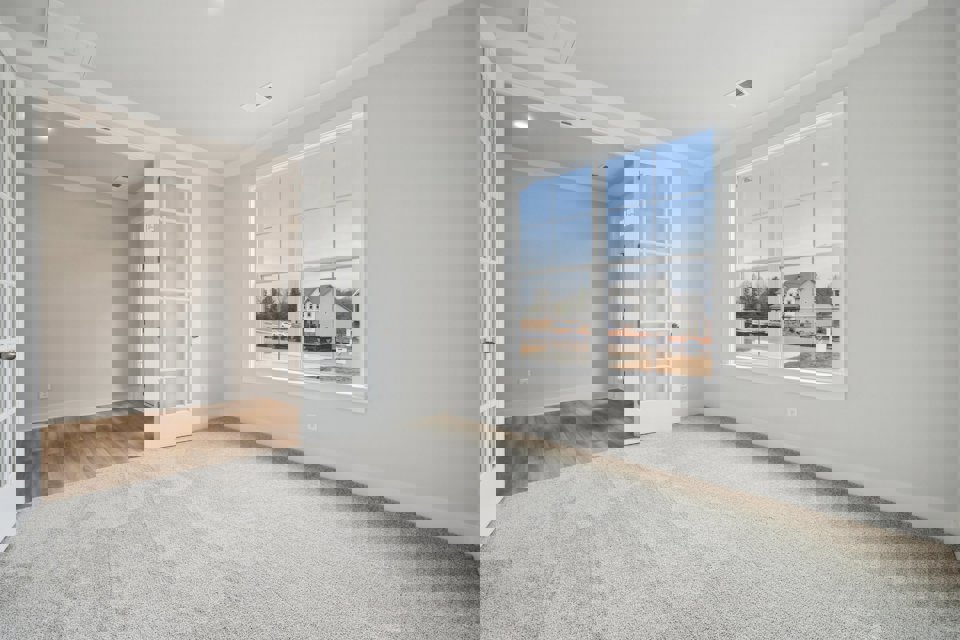 A room with a window and a rug.