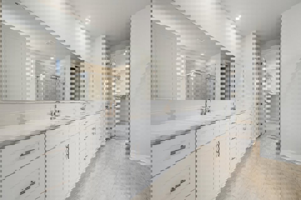 A bathroom with white cabinets.