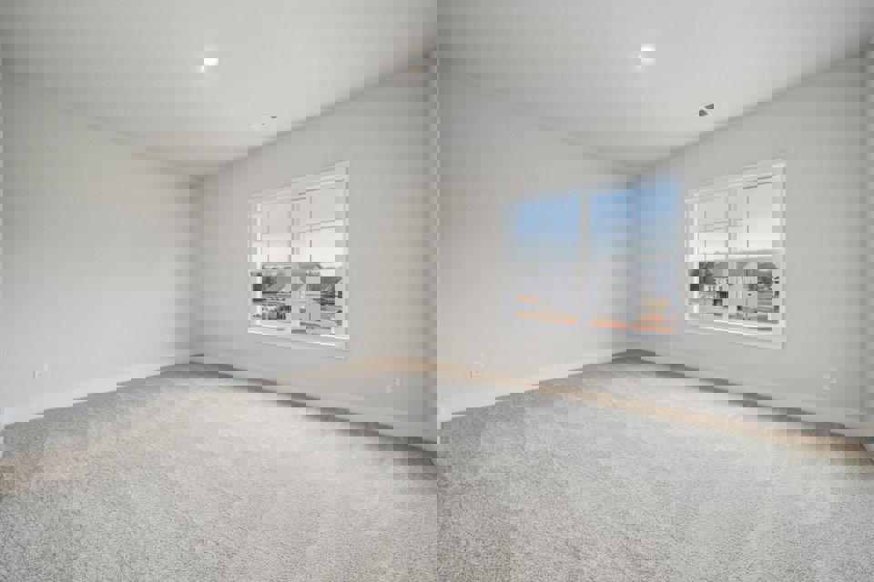 A room with a window and a carpet.