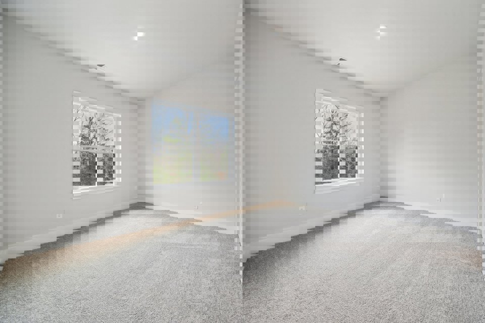 A room with a window and a carpet.