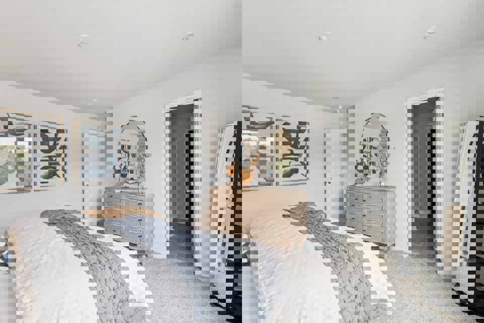 A bedroom with a bed and dresser.