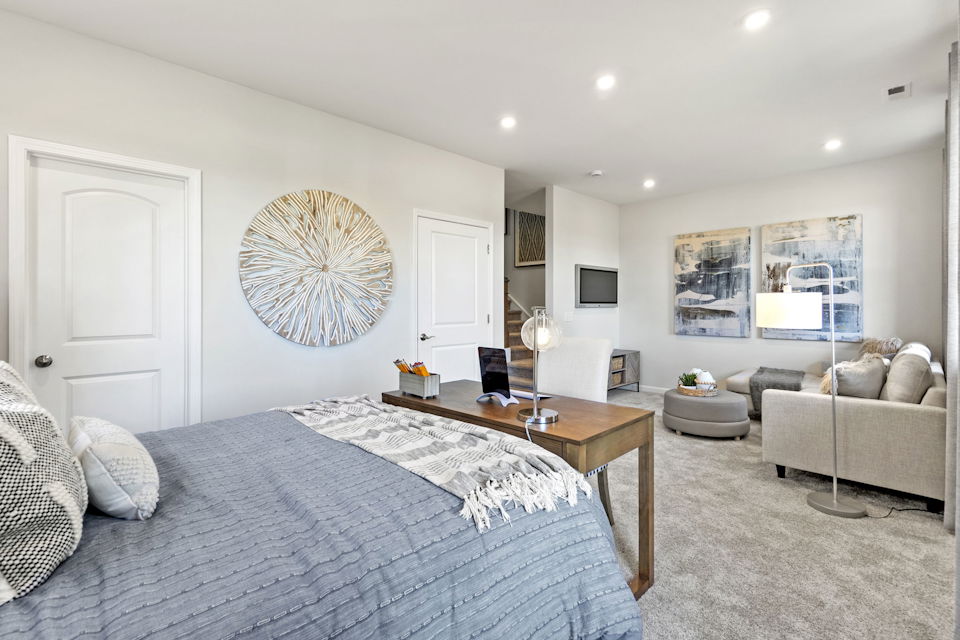 A bedroom with a bed and a table.
