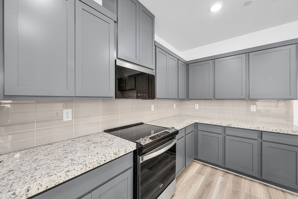 A kitchen with white cabinets.