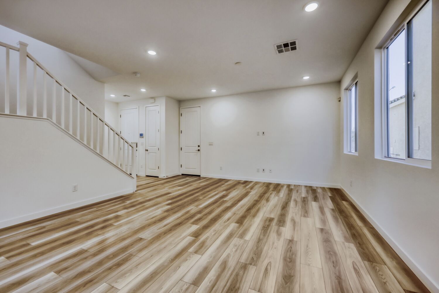 A room with white walls and wood floors.