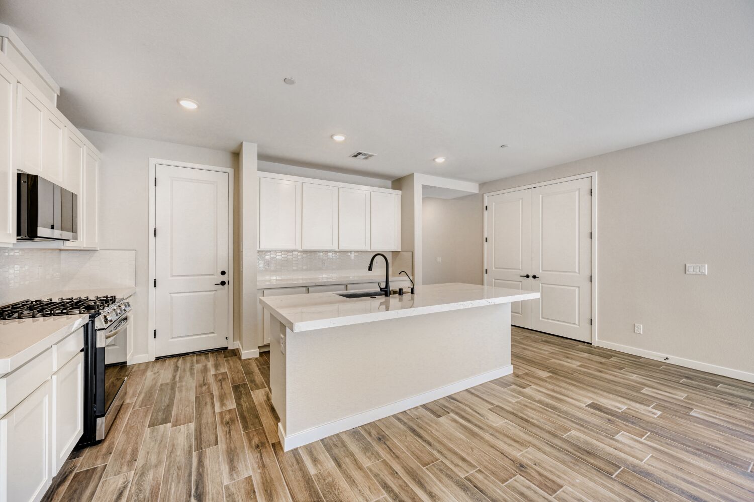 A kitchen with white cabinets.