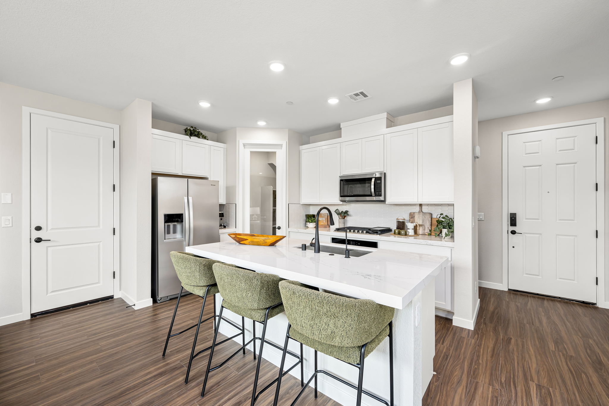 A kitchen with white cabinets.