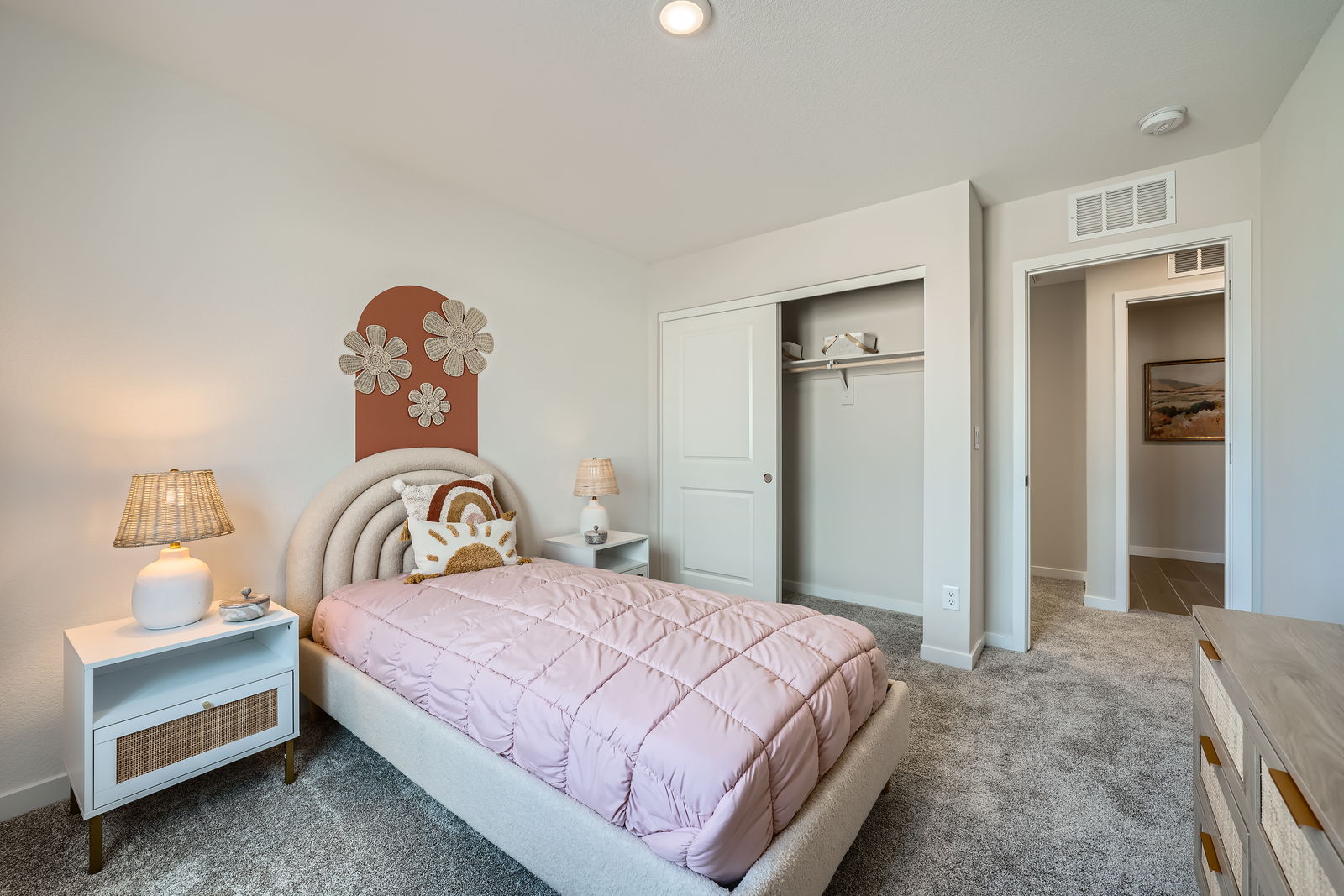 A bedroom with a pink bed.